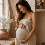femme enceinte d'environ 6 mois réfléchit à sa liste de naissance