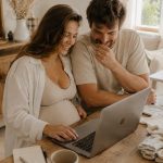 couple devant un ordinateur préparant leur liste de naissance
