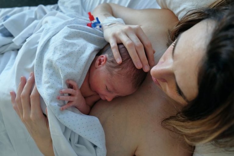 Projet de naissance césarienne : maman en peau à peau avec son nouveau-né allongé sur sa poitrine quelques instants après la naissance.