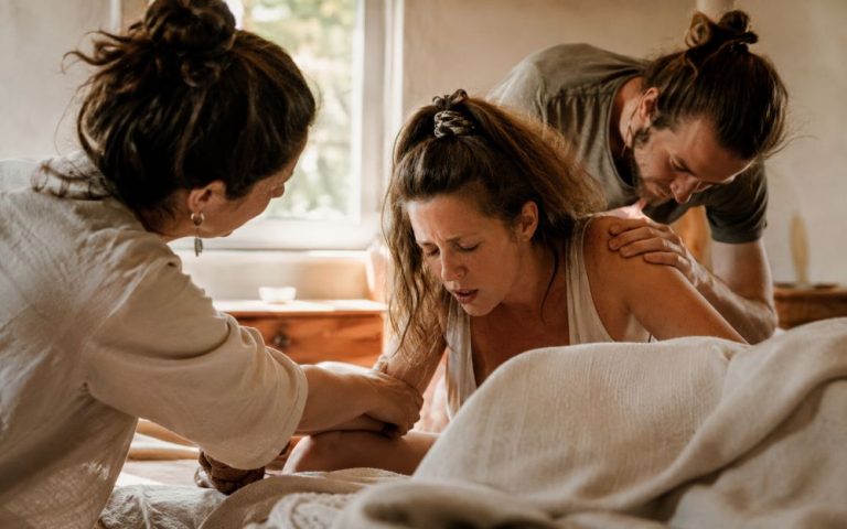 Maman en train de gérer les contractions avec le papa et la sage-femme comme elle l'avait demandé sur son projet de naissance physiologique