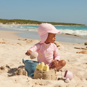 aller à la plage avec bébé et bien le protéger grâce à une casquette sui protège la nuque et un maillot anti-uv