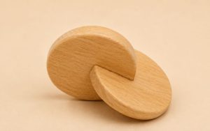 Jouet Montessori disques entrelacés en bois naturel pour développer la coordination des deux mains et la motricité fine de bébé.