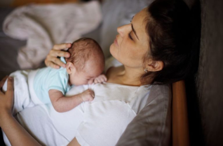 Bébé ne dort pas et s’endort contre sa maman après une nuit difficile.