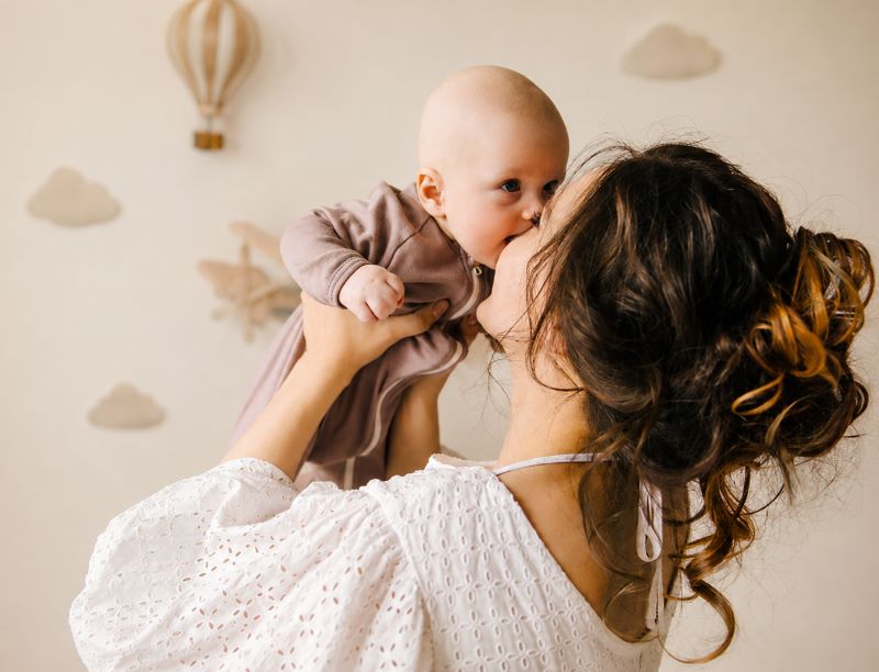 Bébé ne dort pas : une maman prend son nourrisson dans les bras pour l’apaiser avant le sommeil.