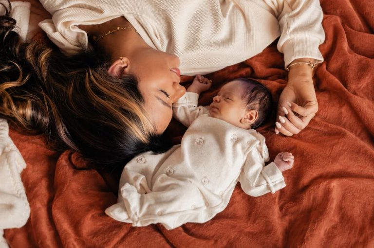 Bébé ne dort pas la nuit je craque : une maman épuisée se repose près de son nouveau-né sur un plaid terracotta, après une nuit difficile.